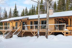 a log cabin in the woods in the snow at Chalet Makabane -Spa- foyer - billard - Slow life in La Malbaie +12 photos