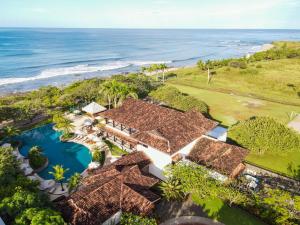 an aerial view of a resort with a pool and the ocean at Luxury Vacation Rentals At Hacienda Pinilla in Tamarindo