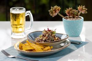 a plate of salad and chips and a glass of beer at Luxury Vacation Rentals At Hacienda Pinilla in Tamarindo