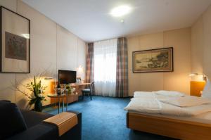 a hotel room with a bed and a desk at Hotel Unger in Stuttgart