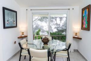 a dining room with a glass table and chairs and a window at Nan La Tigra in El Rosario
