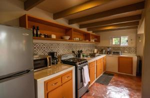 a kitchen with a stove and a refrigerator at Nan La Tigra in El Rosario