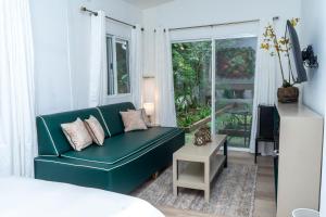 a living room with a green couch and a window at Nan La Tigra in El Rosario