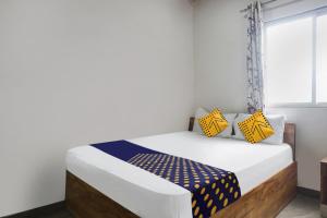מיטה או מיטות בחדר ב-OYO Malhar Lodge