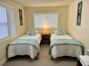 two beds in a room with two windows at Great downtown Sandpoint location! in Sandpoint