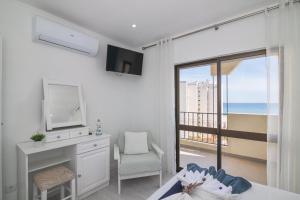 a bedroom with a bed and a desk with a television at Cruzeiro - Silhueta Citadina in Portimão