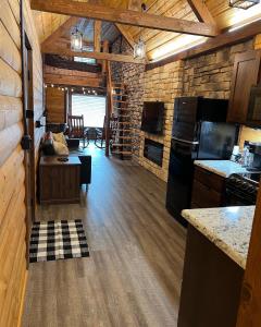 a kitchen with black appliances and a dining room at Limestone Lodge in Sabetha