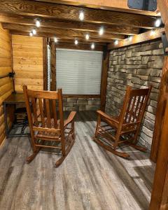 duas cadeiras de baloiço sentadas numa sala com uma mesa em Limestone Lodge em Sabetha