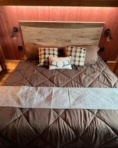 a large bed with two pillows on top of it at Limestone Lodge in Sabetha