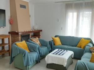 Villa Garbí by Alvent Holidays في كالونج: غرفة معيشة مع كنبتين زرقاوين ومدفأة