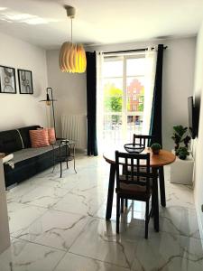 uma sala de estar com uma mesa e cadeiras e um sofá em Apartament Ania Stare Miasto em Elblag