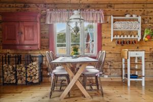 a dining room with a table and chairs and a window at Sjøhaug Rorbu, Fishcermanns cabin in Moskenes
