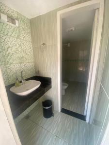 uma casa de banho com um lavatório e um WC em SITIO AMANHECER VERDE em Contagem