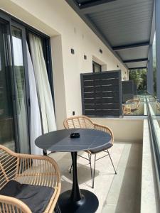 patio con mesa y sillas en el balcón en Tramonto Maisonettes & Suites en Parga