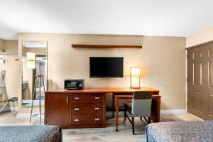 een hotelkamer met een bureau en een televisie aan de muur bij Econo Lodge Texarkana I-30 in Texarkana - Texas
