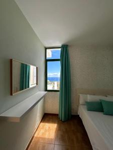 um quarto com uma cama e uma grande janela em Apartamentos Halley em Puerto Rico de Gran Canaria