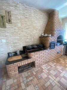 uma cozinha de tijolos com uma parede de tijolos com panelas e frigideiras em SITIO AMANHECER VERDE em Contagem