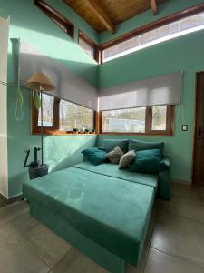 um quarto com uma grande cama verde num quarto em Bosques de ñires em Ushuaia