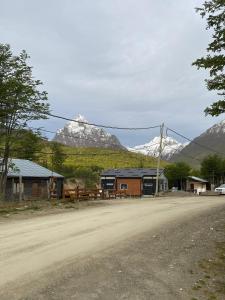 a house on the side of a dirt road with mountains at Bosques de ñires in Ushuaia
