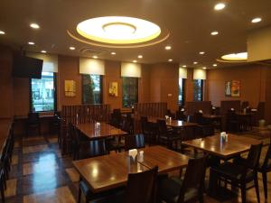 a dining room with wooden tables and chairs at Hotel Route-Inn Hirosaki Joto in Hirosaki