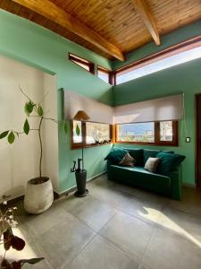 uma sala de estar com um sofá verde e uma janela em Bosques de ñires em Ushuaia