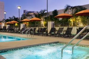 a pool with chairs and umbrellas in a hotel at Residence Inn by Marriott Los Angeles Pasadena/Old Town in Pasadena