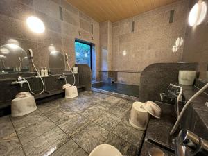 Hotel Route-Inn Hirosaki Joto في هيروساكي: حمام بثلاث مغاسل ودورتين مياه