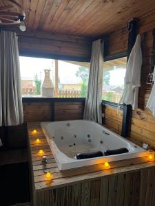 a large bath tub in a room with a window at Chalés Refúgio Ohana in Urubici