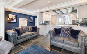 a living room with two couches and a kitchen at Ross Cottage in Hawkshead