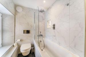 a bathroom with a tub and a toilet and a sink at Ross Cottage in Hawkshead +19 photos