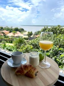 uma mesa com um copo de sumo de laranja e uma bebida em Appartements 4 étoiles - Les Hauts du Fort em Beau Soleil