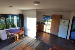 een woonkamer met een tafel en een koelkast bij The Barnyard Cottage in Otakiri +11 foto's