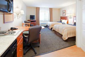 a hotel room with two beds and a desk at Candlewood Suites New Bern, an IHG Hotel in New Bern