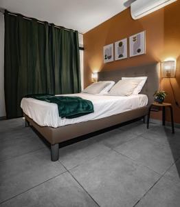een slaapkamer met een bed met een groene deken erop bij Appartements 4 étoiles - Les Hauts du Fort in Beau Soleil