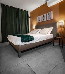a bedroom with a bed with a green blanket on it at Hauts du Fort - Résidence 4 Étoiles in Beau Soleil