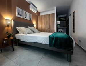 Un dormitorio con una cama con una manta verde. en Appartements 4 étoiles - Les Hauts du Fort en Beau Soleil