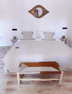 - une chambre avec un grand lit blanc et un miroir dans l'établissement Zagora Oasis Lodge, à Zagora