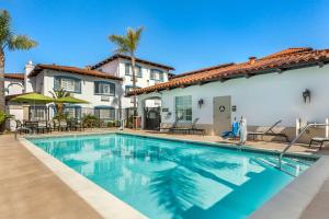 a swimming pool in front of a house with palm trees at Best Western Plus Capitola By-the-Sea Inn & Suites in Capitola