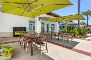 a patio with tables and chairs and umbrellas at Best Western Plus Capitola By-the-Sea Inn & Suites in Capitola