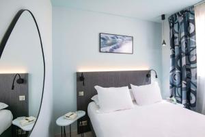 a hotel room with a bed and a mirror at Best Western Alba in Nice