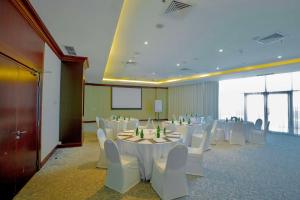 a conference room with white tables and white chairs at Radisson Blu Resort, Fujairah in Dibba