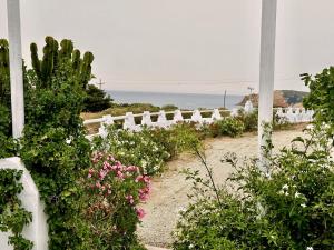 a garden with flowers and a white fence at Errika's Sweet Home in Provatas