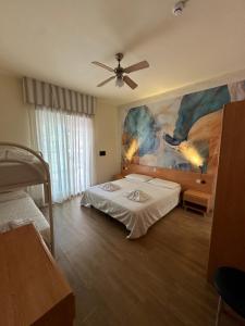 a bedroom with two beds and a painting on the wall at LA MAISON by Hotel Aldebaran in Lido di Jesolo
