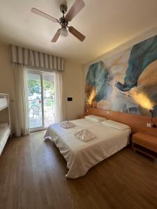 LA MAISON by Hotel Aldebaran في ليدو دي يسولو: غرفة نوم بسرير ودهان على الحائط