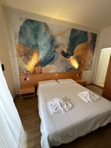 a bedroom with a bed with umbrellas on the wall at Hotel LA MAISON by Aldebaran in Lido di Jesolo