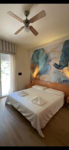LA MAISON by Hotel Aldebaran في ليدو دي يسولو: غرفة نوم مع سرير ومروحة سقف