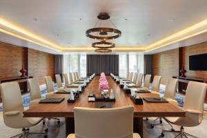 فندق سيام كمبنسكي بانكوم - SHA Extra Plus Certified في بانكوك: قاعة اجتماعات كبيرة مع طاولة وكراسي طويلة