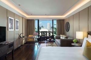 um quarto de hotel com uma cama e uma sala de estar em Siam Kempinski Hotel Bangkok - SHA Extra Plus Certified em Bangkok