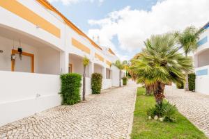 uma rua numa villa com palmeiras em Oasis Beach Apartments na Praia da Luz