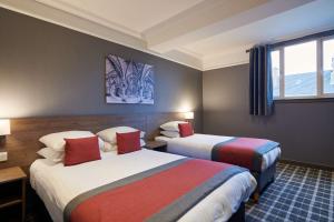 Best Western Glasgow Hotel في غلاسكو: غرفة فندقية بسريرين ونافذة